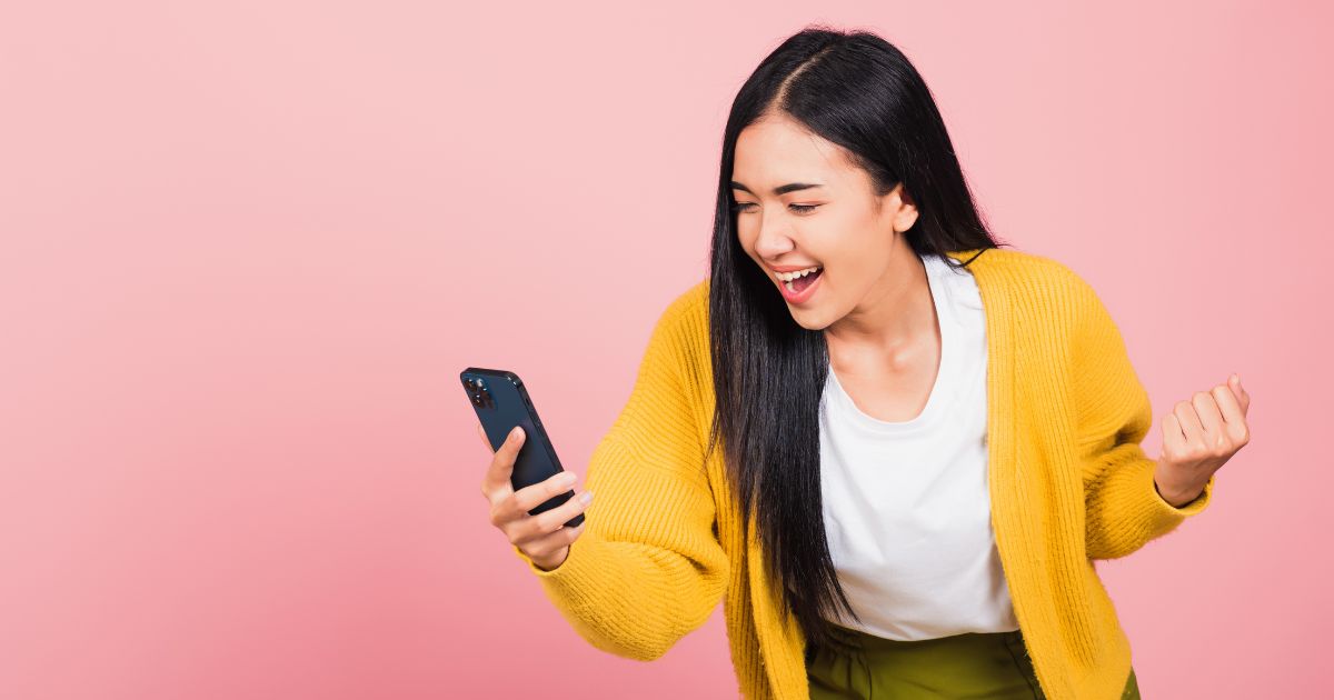 woman excited looking at social media content on her phone.